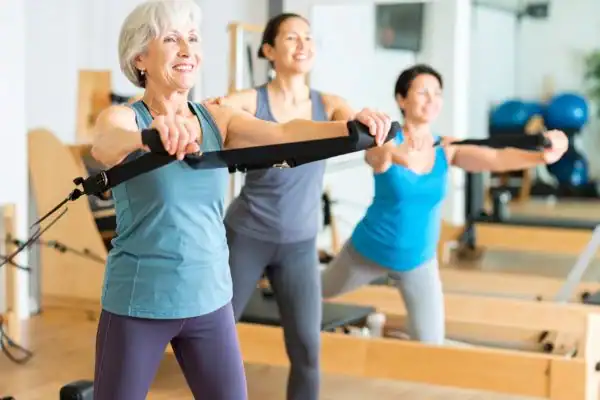 Toning Arms After 60: Empowering Womens Fitness Through Effective Weight Training 2 older woman doing weight training Lowestoft and resistance in the gym to tone upper arms