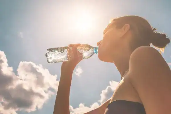 Hydration: The Secret Ingredient for a Toned Stomach and Enhanced Fitness 3 Image of woman drinking water to hydrate Lowestoft after run.